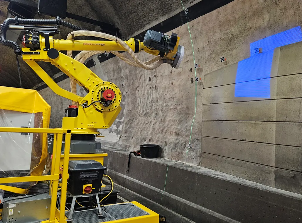 Gele freesrobot op tracks van AIM-Robotics aan het werk tegen de tunnelwand van de Hubertustunnel